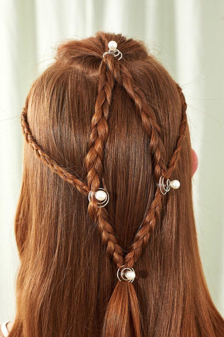 Coiffure pour fille avec tresses croisées sur cheveux roux avec accessoires