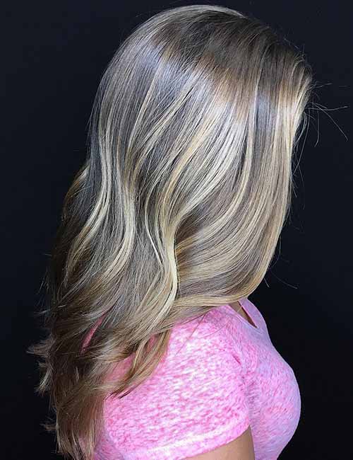 Cheveux bruns ondulés nuancés par mèches blondes cendrés