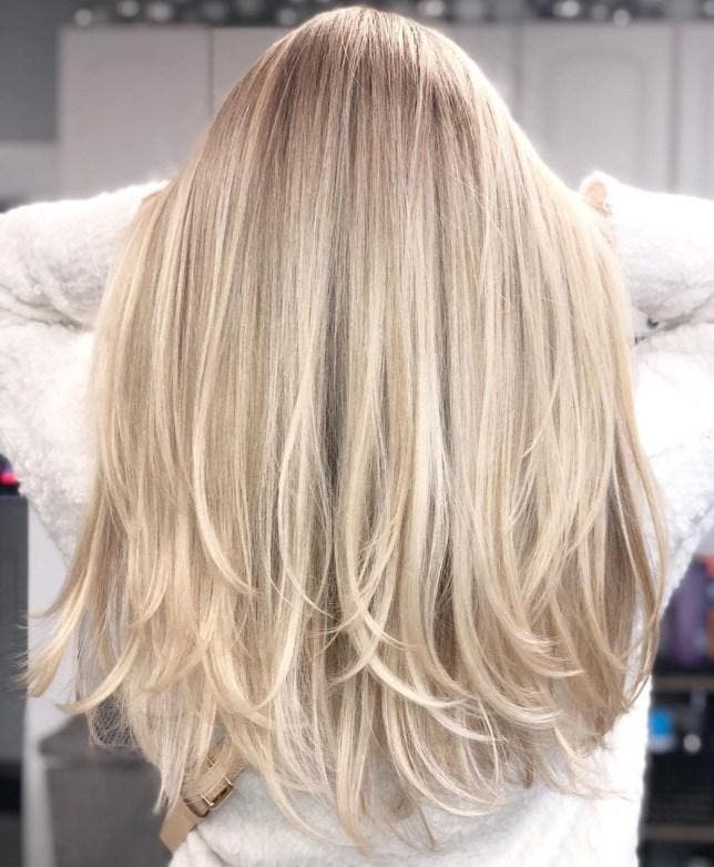 Cheveux longs en blond cendré avec des pointes légèrement effilées