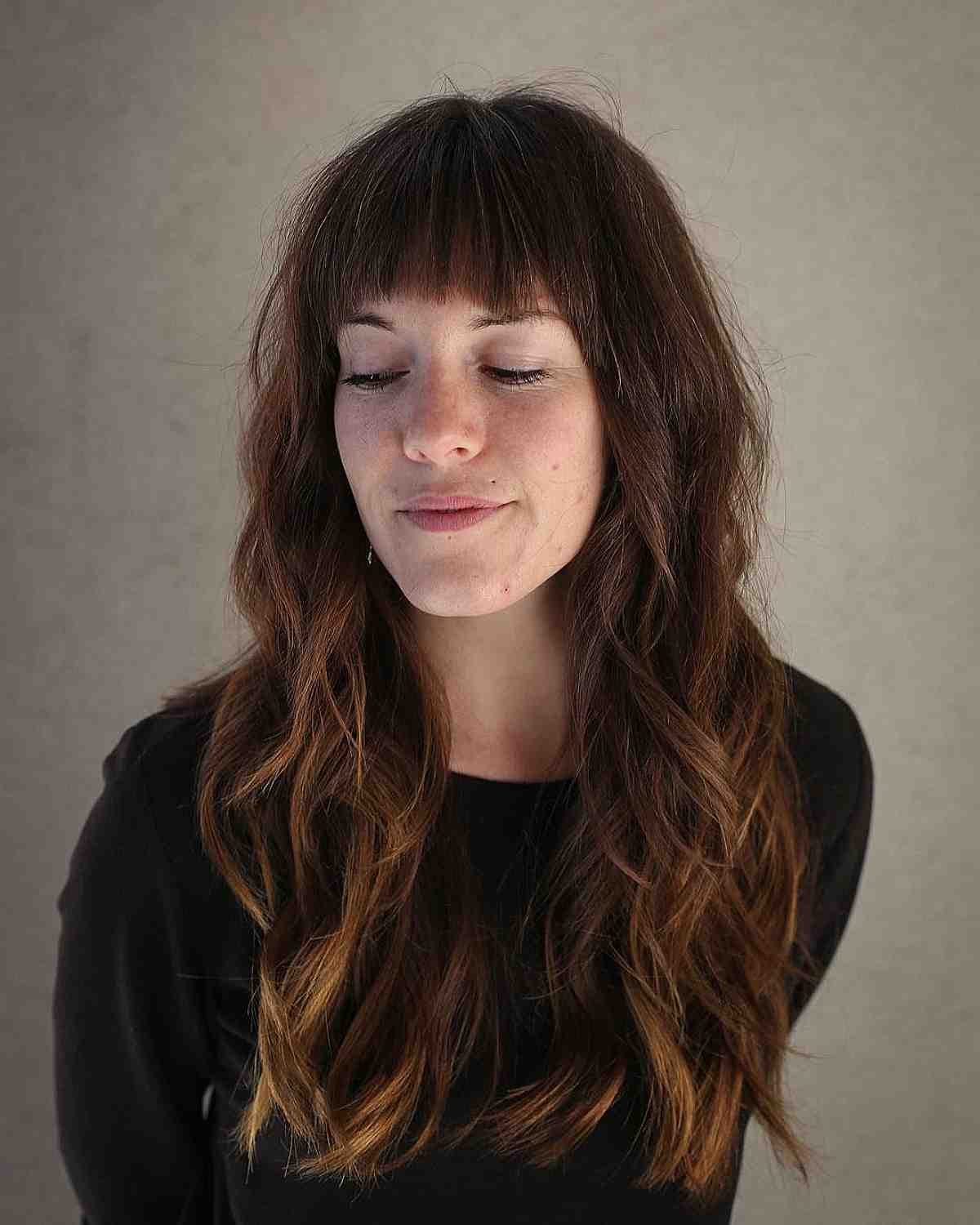 Cheveux longs ondulés avec la “ baby bangs” texturée