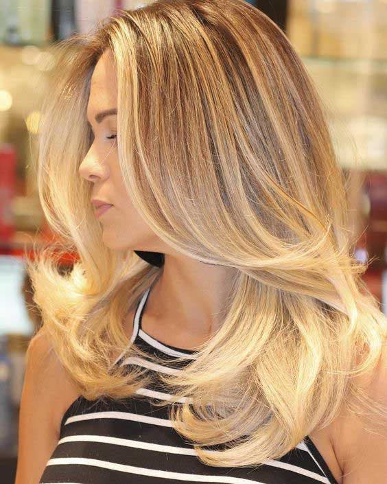 Balayage blond doré sur cheveux mi-longs et frange rideau 