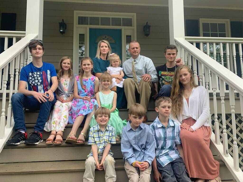 Carly, son mari et ses enfants sur le porche de la maison