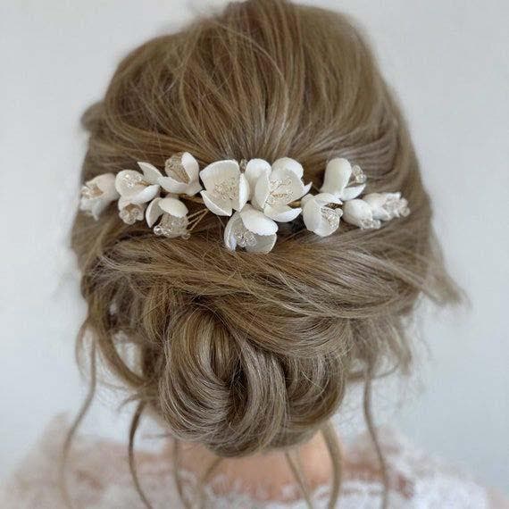 Chignon bas coiffé-décoiffé orné de fleurs blanches