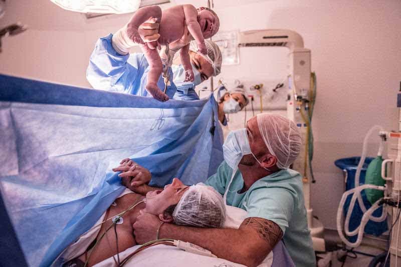 Couple dans un bloc opératoire découvrant leur bébé pour la première fois