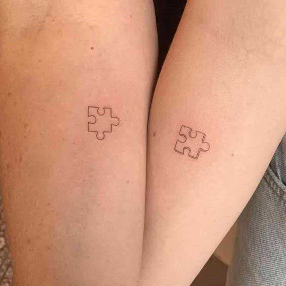 Deux tatouages identiques de pièces de puzzle d'une mère et sa fille