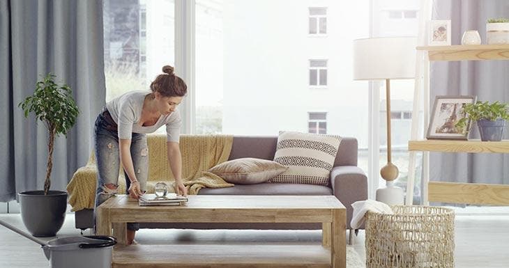 Femme qui nettoie et range la maison 