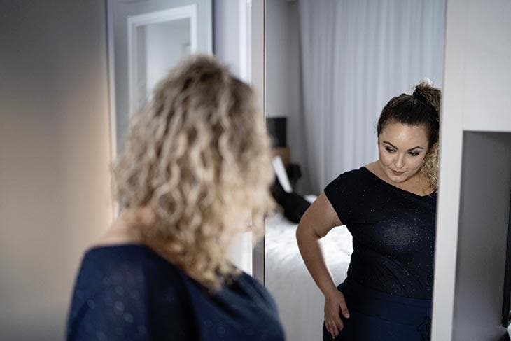 Femme ronde devant un miroir 