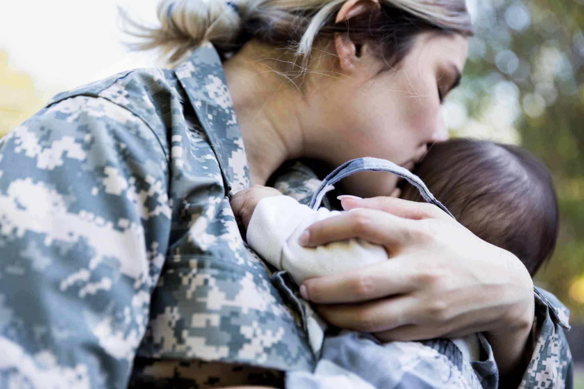 Femme soldat tenant dans ses bras son bébé