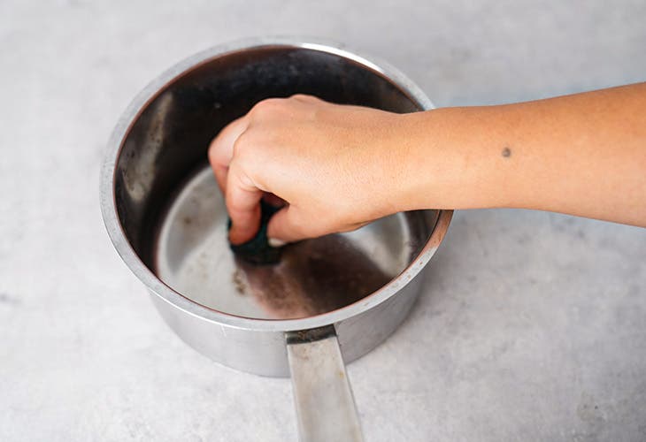 Frottez la casserole pour enlever les résidus brulés à l’aide d’une éponge