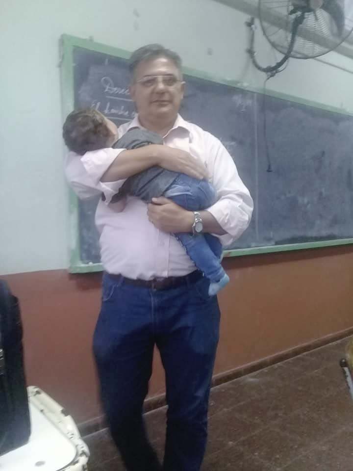 Julio Cruz tient le bébé de son élève