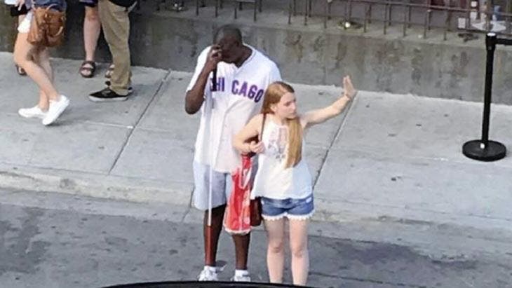La jeune fille aide un aveugle à prendre un taxi