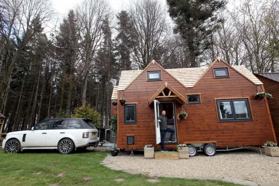 La maison en bois est installée dans un terrain