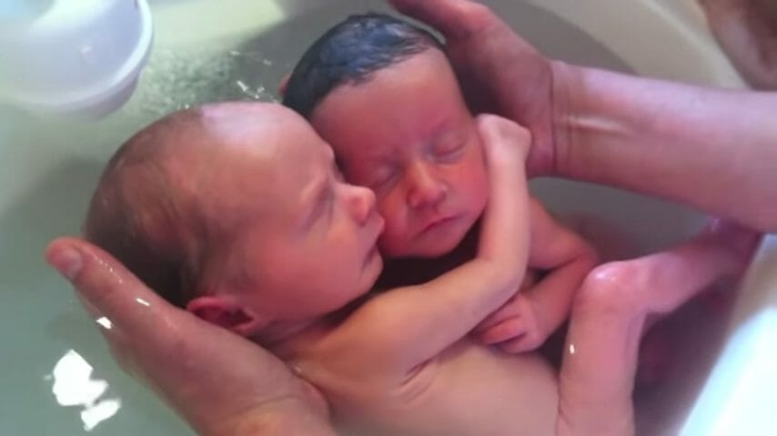 Les jumeaux se touchent et se font des câlins dans l’eau