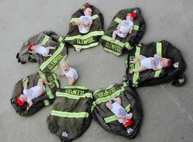 Les nouveaux-nés des septs pompiers allongés sur les vestes de leurs pères