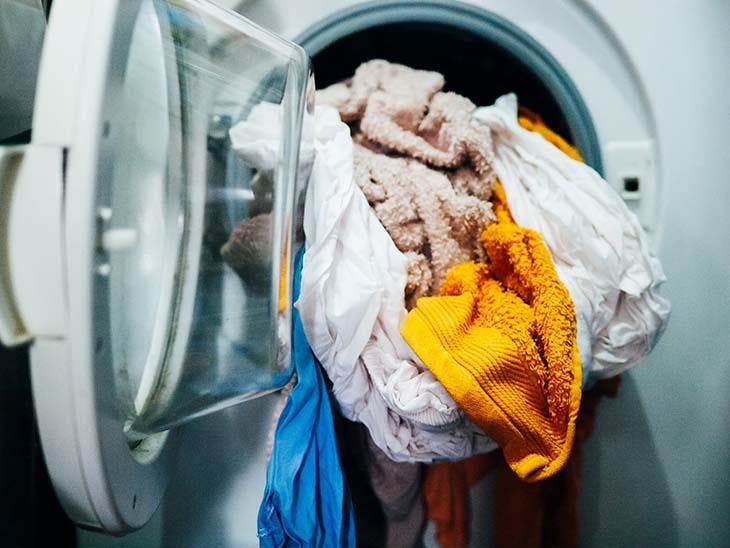 Mettre des vêtements dans le tambour de la machine à laver