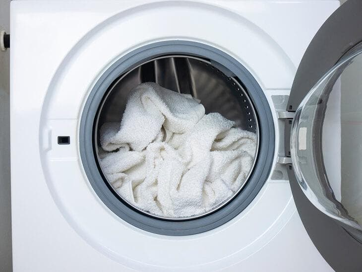 Mettre les serviettes dans la machine à laver 