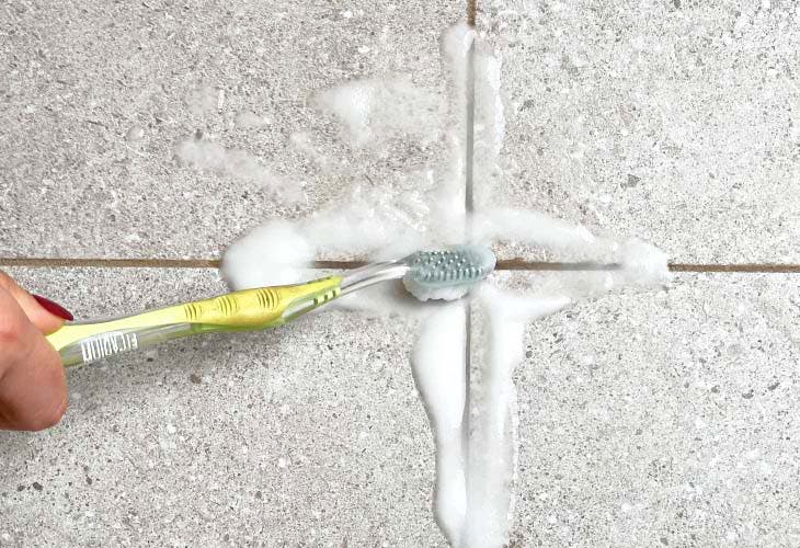 Nettoyer les joints de carrelage avec une brosse à dents, du bicarbonate et de l’eau oxygénée