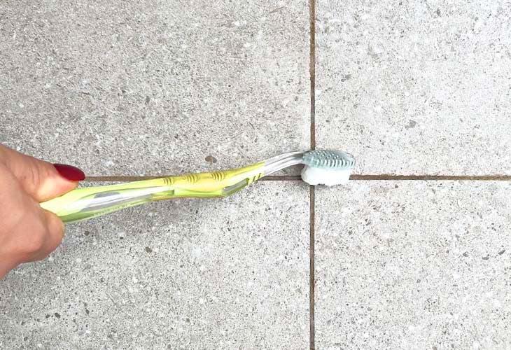 Nettoyer les joints de carrelage avec une brosse à dents et de l’eau de javel