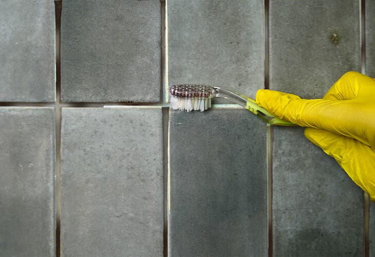 Nettoyer un joint jauni de la salle de bain avec une brosse à dents