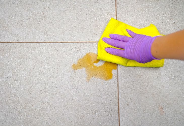 Nettoyer une tache de café sur le carrelage avec un chiffon