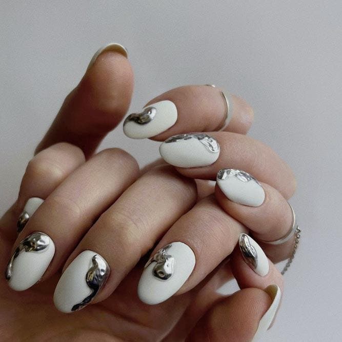 Ongles en acrylique blanc avec motifs argentés