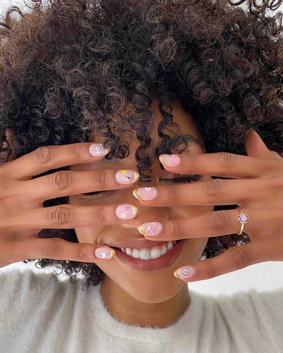 Ongles nudes avec des motifs de fleurs et cœurs 