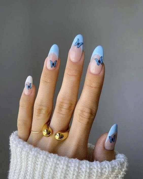 Ongles ovales avec des motifs papillon en bleu
