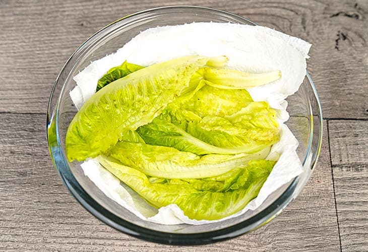 Placez la salade dans un récipient en verre avec du papier absorbant