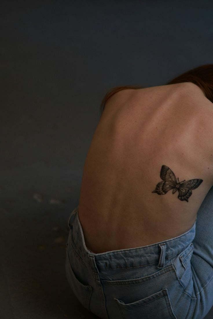 Tatouage de papillon au centre du côté droit du dos