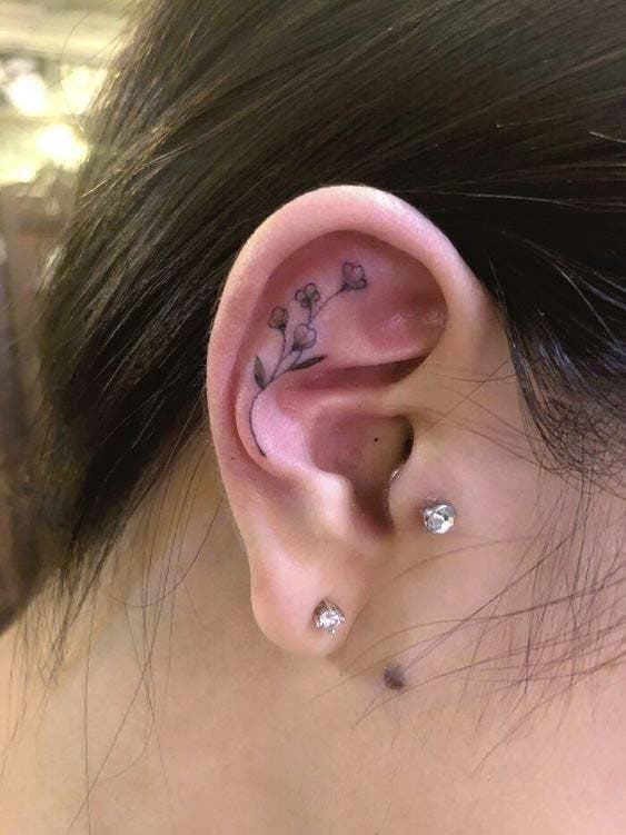 Tatouage floral délicat sur l’oreille