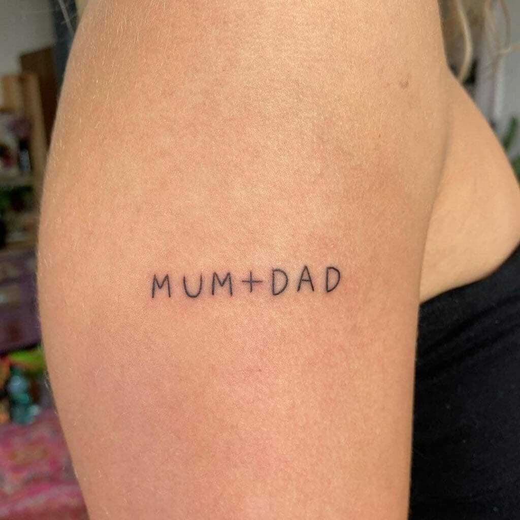 Tatouage minimaliste en anglais « Mum + Dad » qui représente l'amour pour ses parents 
