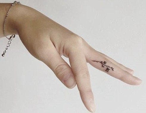 Tatouage simple et minimaliste sur un doigt