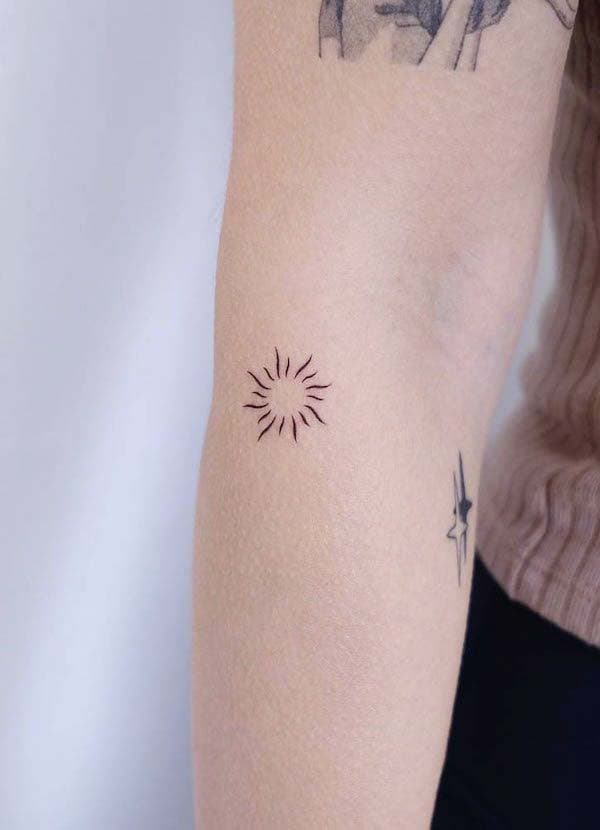 Tatouage soleil minuscule sur l’avant-bras