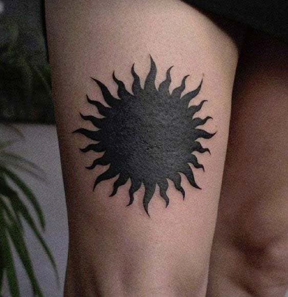 Tatouage soleil noir sur la jambe