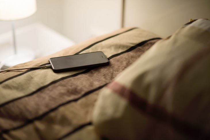 Téléphone portable en charge sur le lit. source : spm