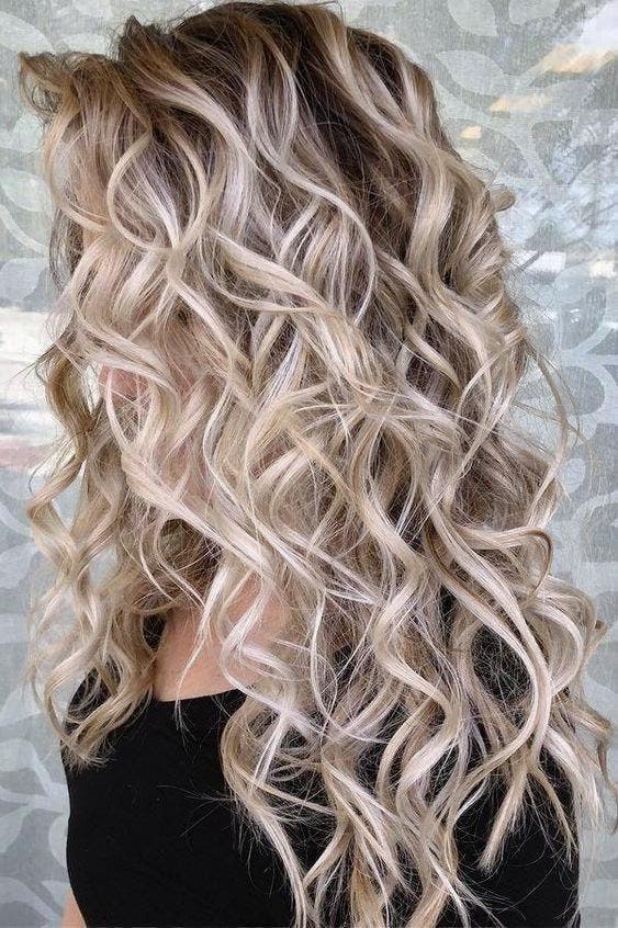 Un balayage blond sur des cheveux ondulés