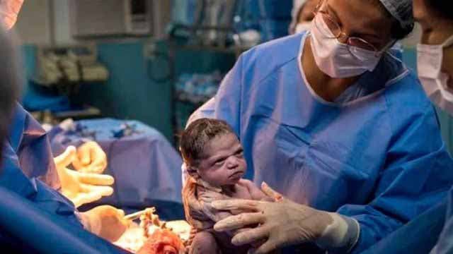 Un nouveau-né avec un regard noir adresse au médecin