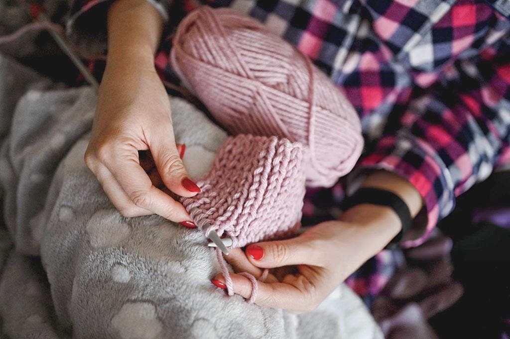 Une femme tricote les mailles