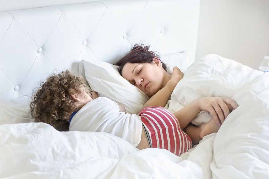 Une maman qui dort avec son enfant