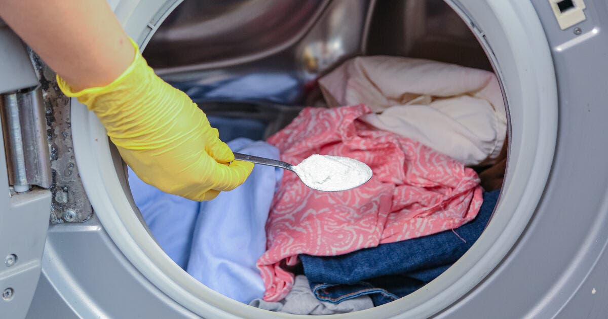 Verser une cuillère de percarbonate de soude dans la machine à laver pour blanchir le linge