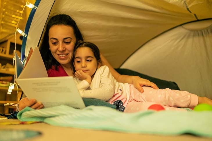 Une maman qui lit une histoire à sa fille le soir 