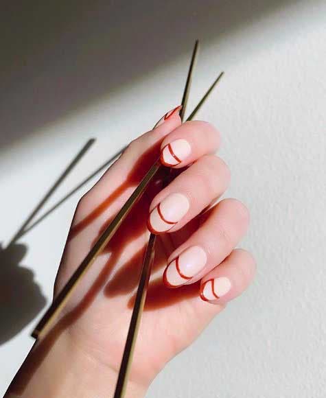 Lignes rouges sur des ongles clairs