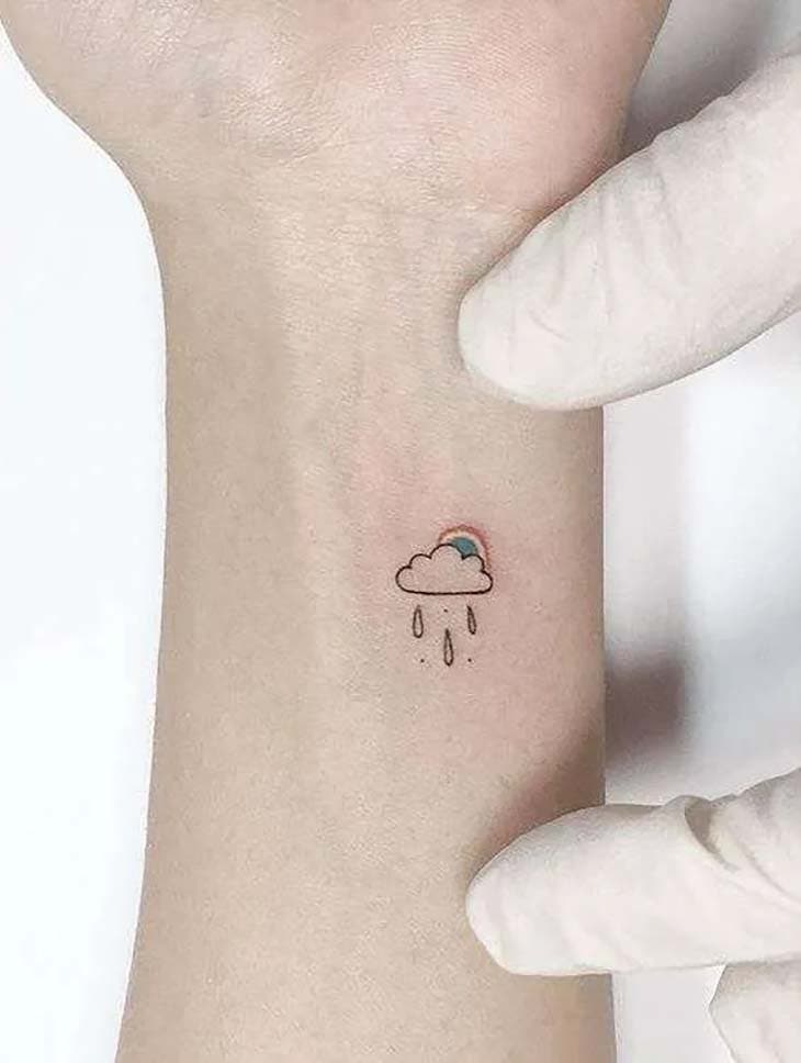 Tatouage nuage pluvieux avec arc-en-ciel derrière