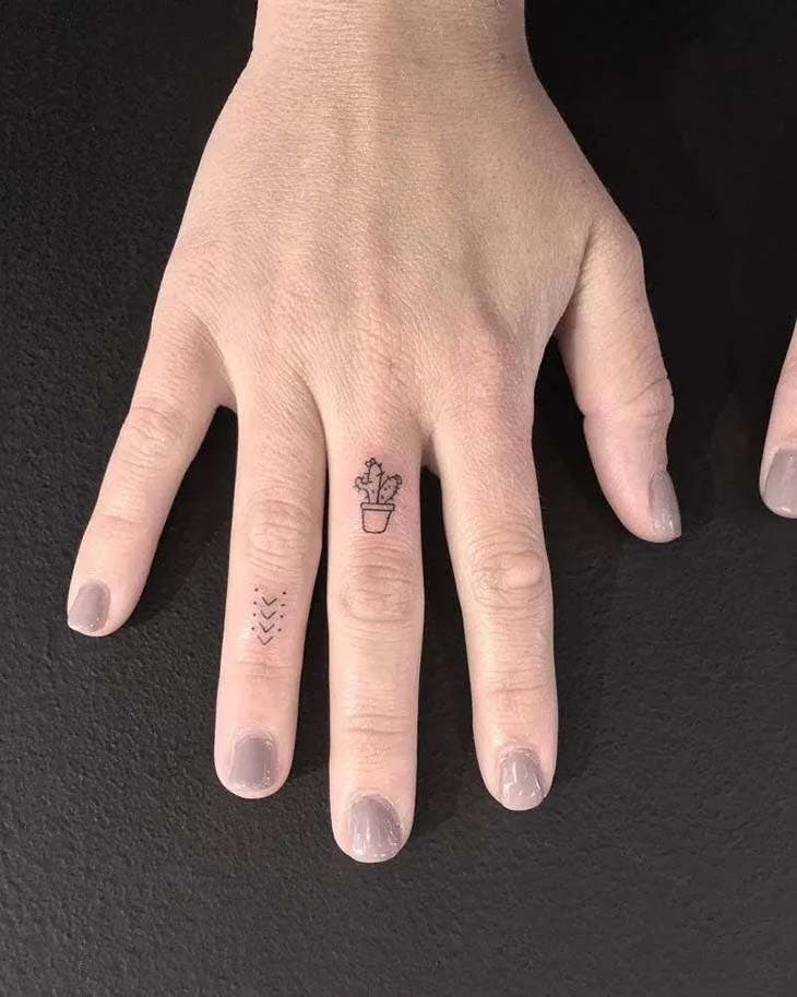 Petit cactus tatoué sur le doigt majeur