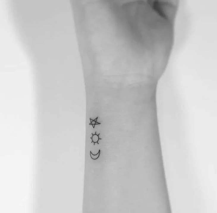 Croissant de lune, petit soleil et étoile, tatoués sur le poignet