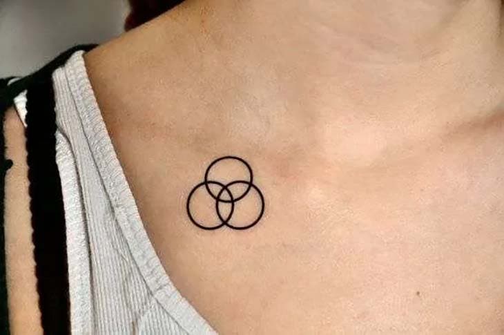 Trois anneaux entrelacés tatoués sur le torse pour femme. 