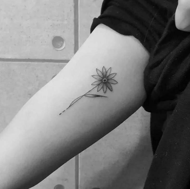 Tournesol tatoué sur le bras d’une femme