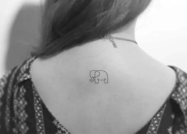 Petit éléphant tatoué sur le haut du dos d’une jeune fille