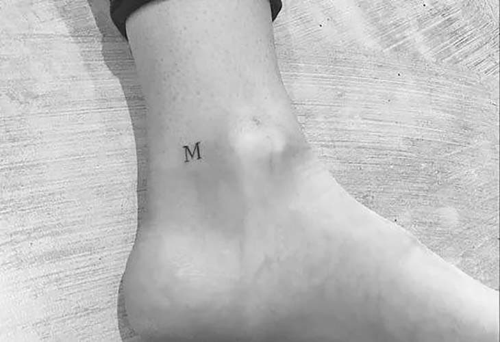 Le tatouage de la lettre “m” sur la cheville, un tatouage discret. 
