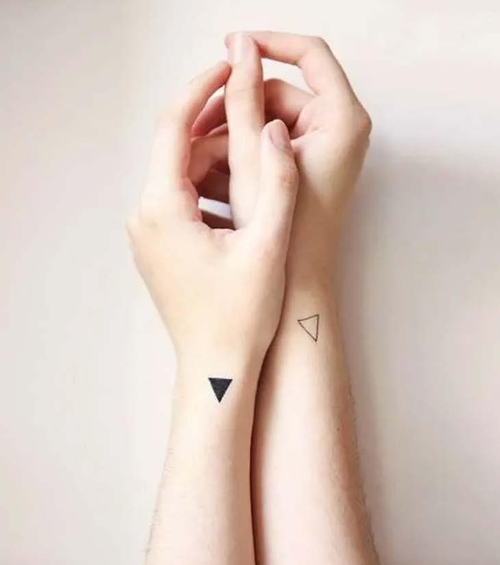 Tatouage d’un triangle vide et d’un triangle plein sur les poignées des deux mains
